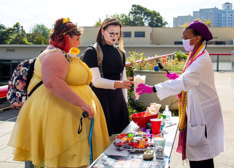 Princess Belle and a mime receives popcorn from a nurse