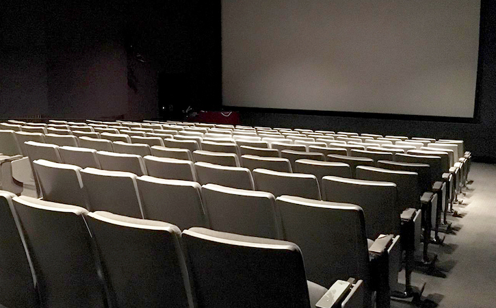 Inside Coppola Theatre with empty chairs and blank screen