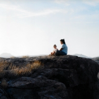 Woman and child sitting on a hill