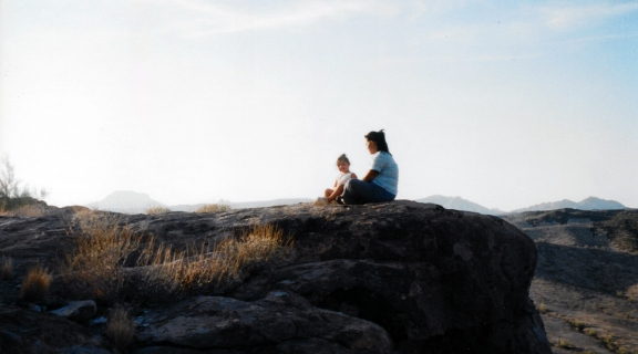 Woman and child sitting on a hill